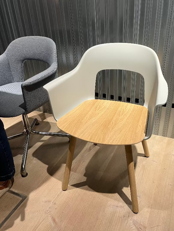 Hay Layout armchair with a wooden seat and white backrest in a room with a textured wall at Hay store 2025 3 days of design.