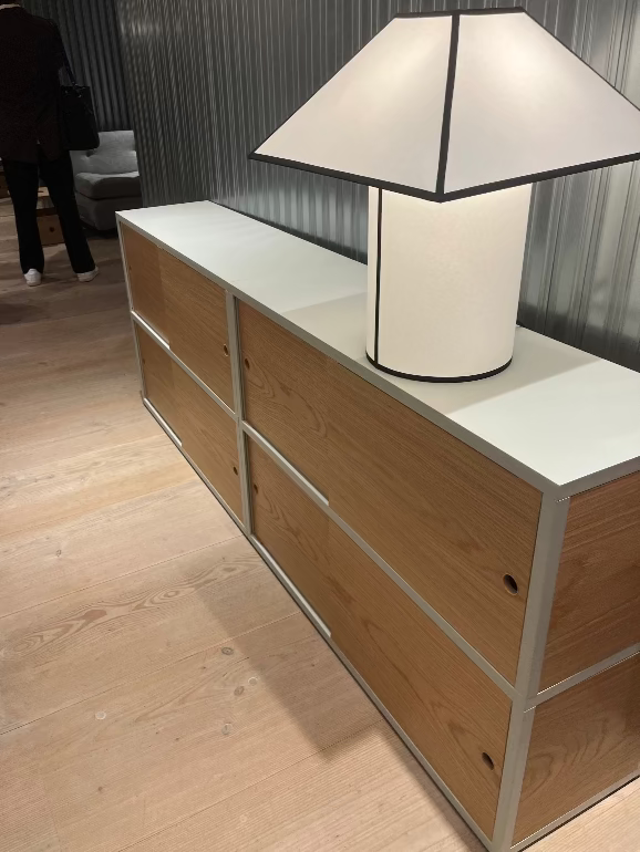 HAY New order Wooden cabinet with sliding oak doors and an Ava lamp on top in an indoor setting