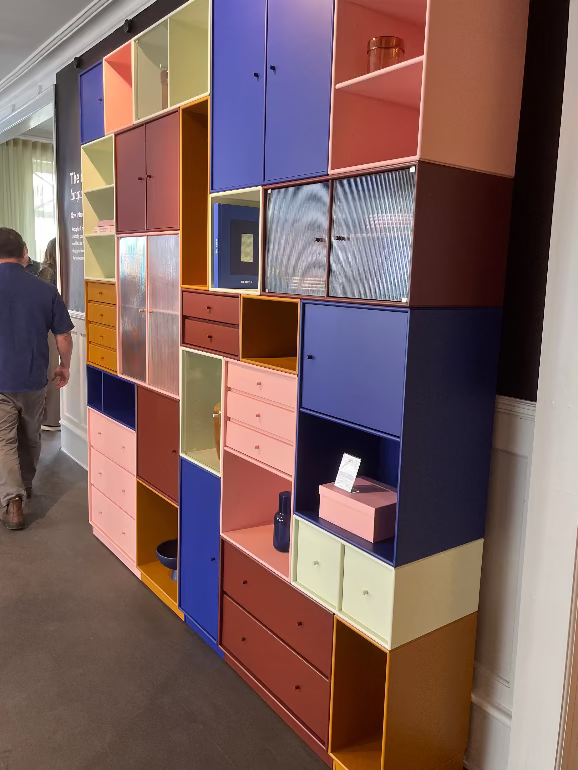 Colorful geometric wall unit with various colored shelves and drawers in a room. Montana shelving at their Copenhagen store during 3DD 2025