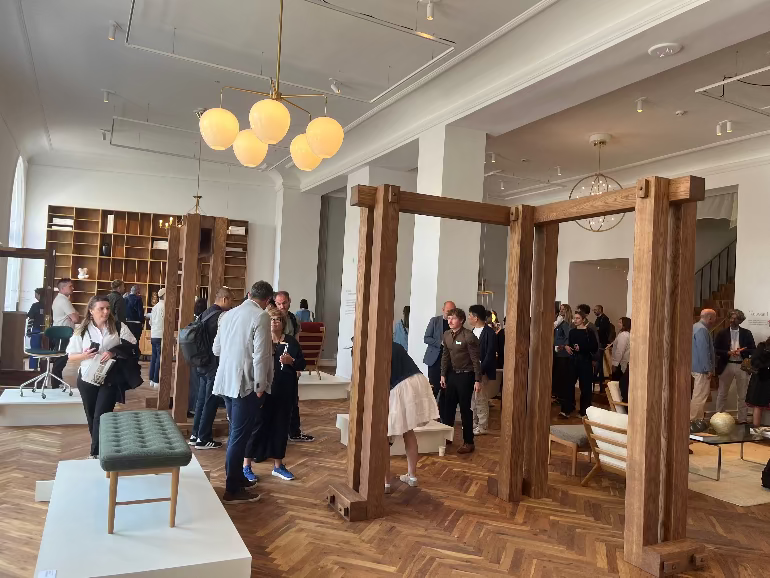 Modern interior with wooden frames and people in a stylish setting. Carl Hansen store in Copenhagen during the 2025 3 days of design festival