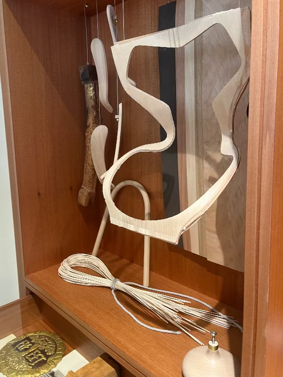 Decorative metal sculpture on a wooden shelf of the template of a grand prix chair as part of Fritz Hansen's archive in their Copenhagen store