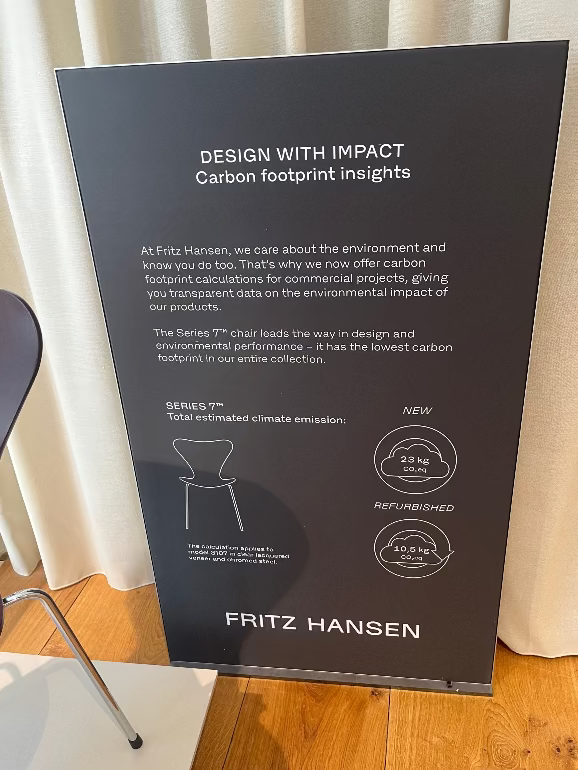 Fritz Hansen sign about carbon footprint insights for their products on a wooden floor. 3DD 2025
