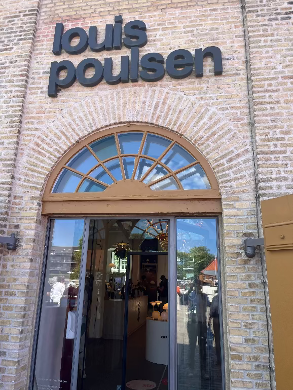 Louis Poulsen store entrance with glass door and brick wall. Copenhagen showroom at 3 days fo design 2025