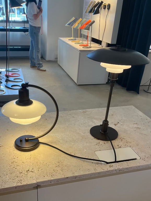 Louis Poulsen PH aged brass Modern table lamps on display in a showroom setting in Copenhagen