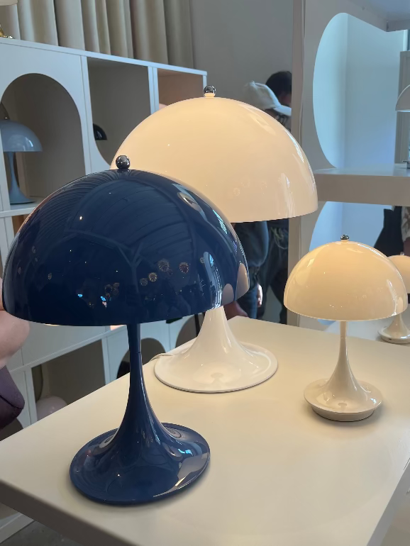 Louis Pouslen Panthella portableTabletop lamps in various colors on a white surface with a blurred indoor background
