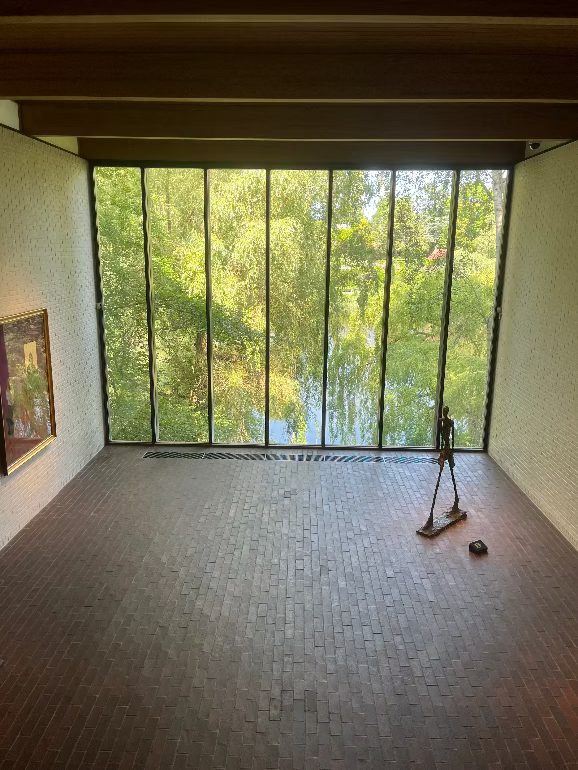 Modern room with large glass window overlooking trees at Lousiana Museum of Modern Art in Denmark