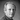 Black and white portrait of Alfred Homann against a dark background