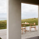 Carl Hansen E022 Embrace Outdoor Dining Table in Teak, D80cm — lifestyle, with E008 Outdoor Dining Chair