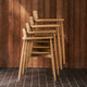 Carl Hansen E008 Embrace Outdoor Dining Chair in Teak — lifestyle, stacked