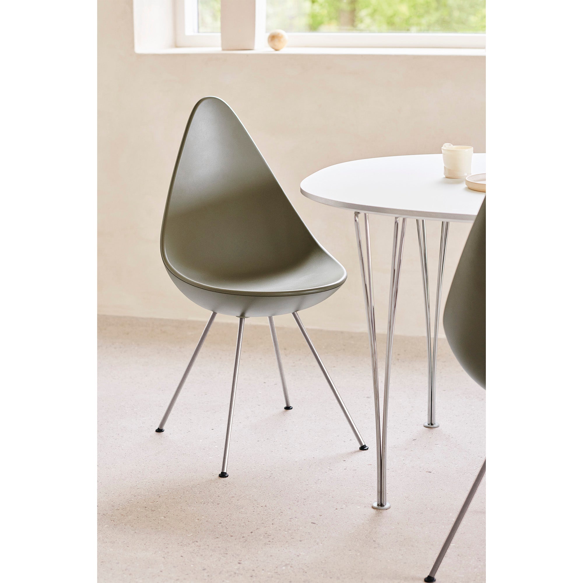 Fritz Hansen 3110 Drop Chair in Olive Green with Chrome base — lifestyle, with Table Series B612