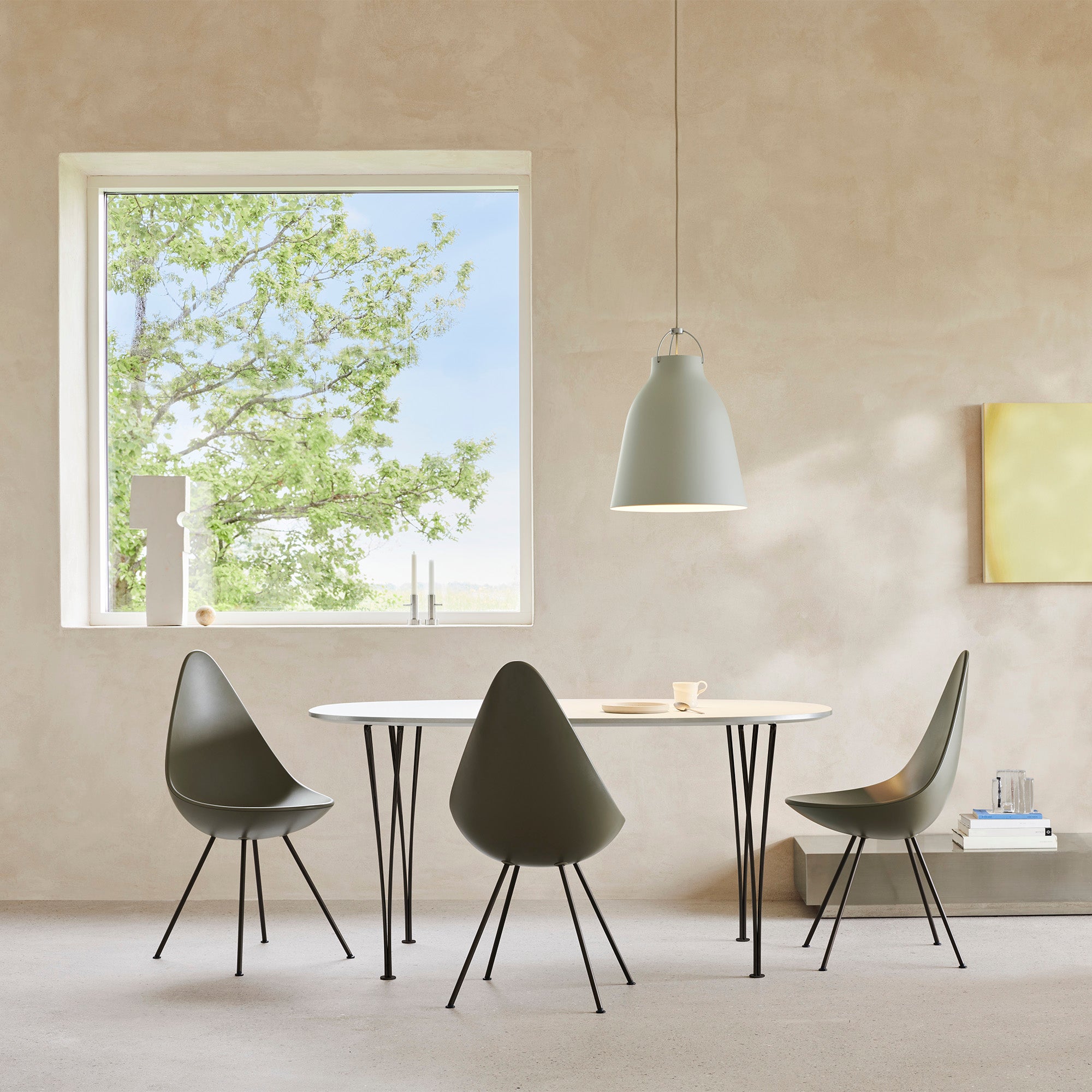Fritz Hansen 3110 Drop Chair with Brown Bronze base — lifestyle, with Table Series B612 and Caravaggio pendant