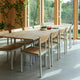 Skagerak Pelagus Outdoor Dining Armchair and Dining Chair with Extendable Dining Table in Light Ivory — lifestyle