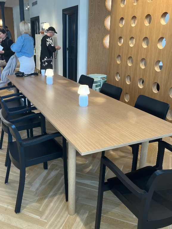 Long wooden Hay Annex dining table with black chairs in a modern interior setting. at Hay House copenhagen during 3daysofdesign 2025