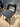 Hay Layout Gray dining chair with black legs on a wooden floor against a striped wall.