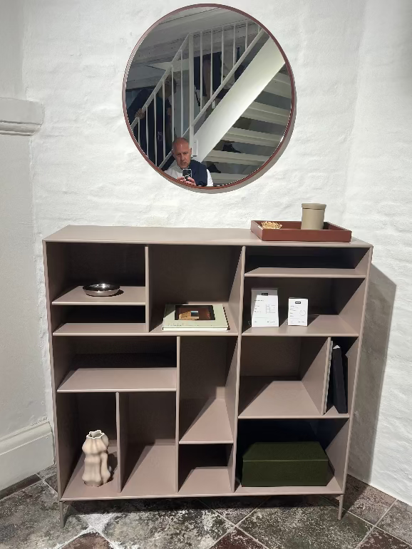Montana Mega Storage. Modern shelving unit with round mirror above it in a room.