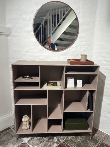 Montana Mega Storage. Modern shelving unit with round mirror above it in a room.