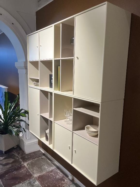 Montana System White storage cabinet with multiple compartments in a room setting.