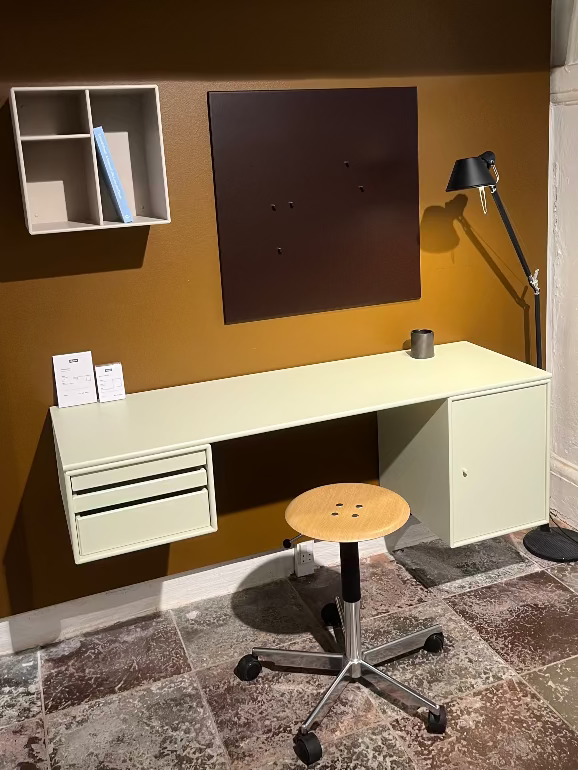 Montana Modern office setup with a desk, chair, and wall-mounted shelves against a brown wall.