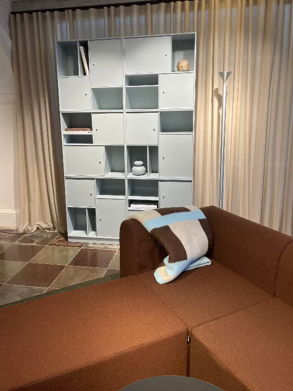Modern living room with a brown sectional sofa and a white bookshelf. Montana Paradigm  modular sofa and montana shelving at Montana store Bredgade Copenhagen 3DD 2025