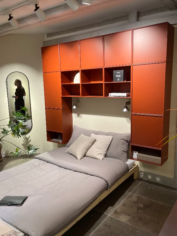 Montana Modern bedroom storage with orange wall cabinets and a bed.
