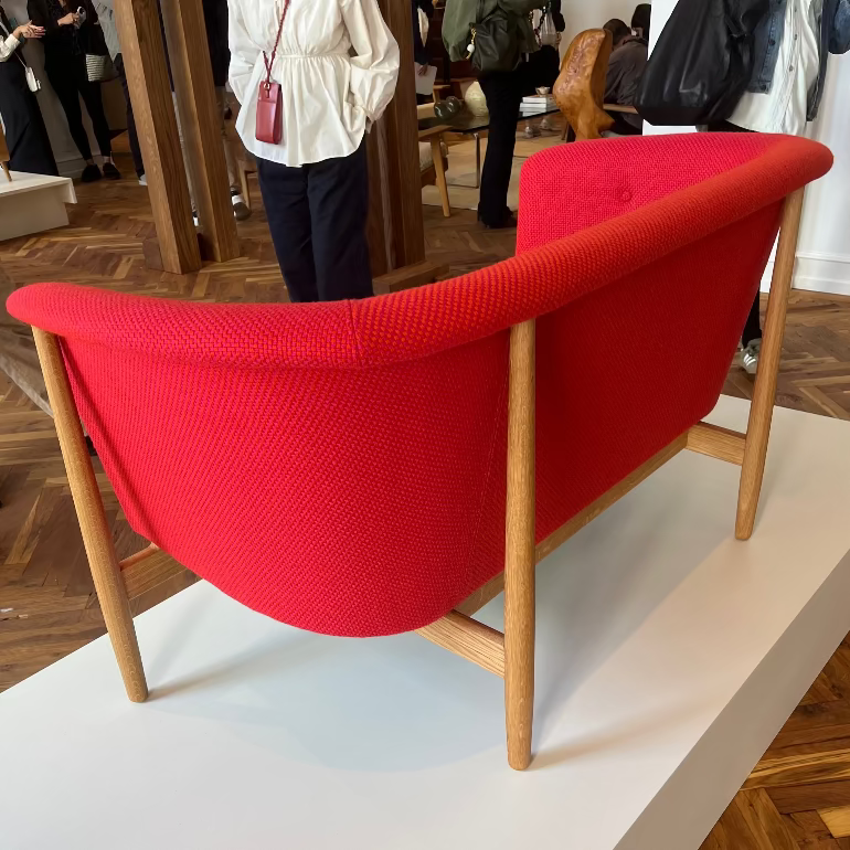 ND52 Nanna Ditzel Red sofa with wooden frame on a white platform in an indoor setting
