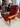 Red armchair with wooden frame on a white platform, people in the background. Carl Hansen Copenhagen showroom 3DD 2025