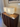 Nonna rectangular table lamp with beige shade on a wooden stand against a neutral wall.