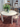 Round white table with chairs and a vase of flowers on a patterned floor. New After dining table and chairs by Michael Anastassiades for Fritz Hansen