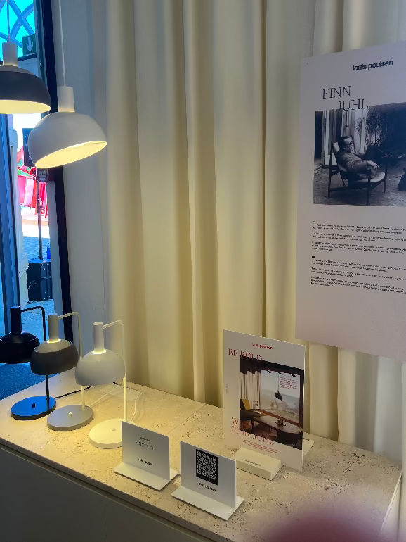 Display of Finn Juhl lamps and informational posters in a Louis Poulsen showroom at 3DD 2025