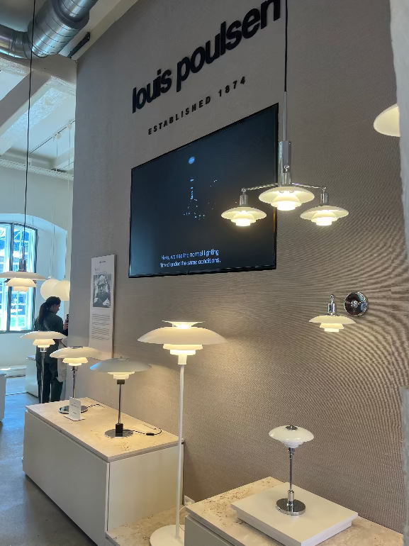 Louis Poulsen lighting display of PH lights with a screen on the wall, featuring various lamps.