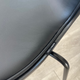 label of Fritz Hansen 3107 Series 7 Dining chair, front upholstered in black essential leather and black ash frame and black lacquered legs in Innes showroom on oak floor