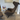 A modern high-back lounge chair upholstered in dark brown fabric with a matching ottoman, shown in a contemporary room with light wood flooring and a small side table. side view of vitra Grand Repos lounge chair with becky innes art print at Innes showroom in Hessle, East Yorkshire