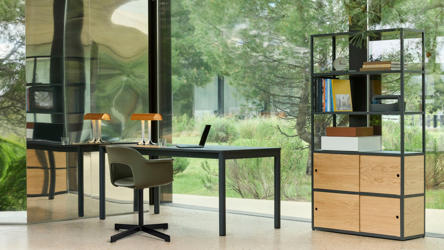 Modern office setup with a desk, chair, and bookshelf in a bright room with large windows. Modern kitchen with a round table and green chairs in a minimalistic setting. Hay Layout upholstered home office chair and Annex desk