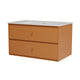 A two-drawer vanity cabinet in a warm terracotta orange finish, featuring a speckled white sink countertop with an integrated sink and small round pull handles, shown on a solid white background.