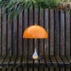 Louis Poulsen Panthella 250 Portable The Originals — Original Orange illuminated in an outdoor setting