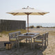 Skagerak Drachmann outdoor furniture collection — lifestyle, with cushions in Lemon/Sand Stripe and Messina Umbrella