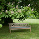 Skagerak Drachmann Outdoor Bench 200 — lifestyle, with Bench Cushion in Light Apricot/Dark Green Stripe