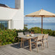 Skagerak Messina Parasol in Golden Yellow Stripe — lifestyle, with Skagerak Ballare Outdoor Dining Chair and Ballare Outdoor Dining Table