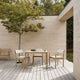 Carl Hansen AH902 Outdoor Dining Table Square in teak — lifestyle, with AH502 Outdoor Dining Chair with Armrests, with cushions