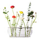 Fritz Hansen Ikebana Vase Long Stainless Steel — packshot, with flowers and foliage